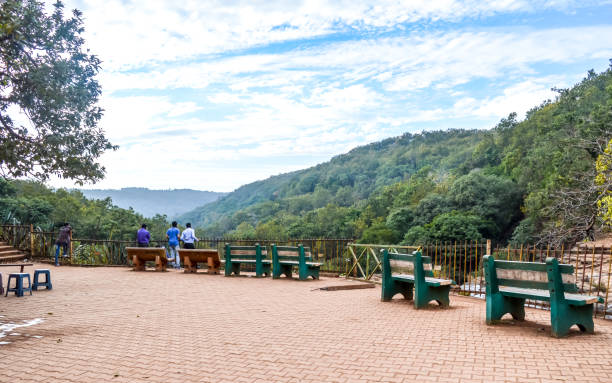 Amarkantak Madhya Pradesh, India December 2018 -  A Beautiful Lawn With Park Bench To Sit And Rest Alone On A Paved Walk With Lush Greenery Surrounded By Satpura And Vindhya Mountain Ranges In The Background. View Of Amarkantak Madhya Pradesh, India